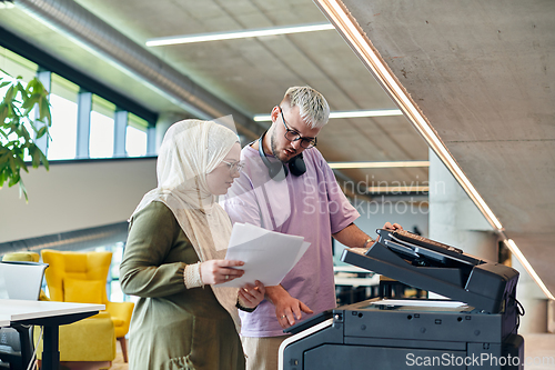 Image of In a modern startup office, a business-minded Muslim woman wearing a hijab collaborates with her colleague, symbolizing diversity, empowerment, and success in the contemporary corporate world