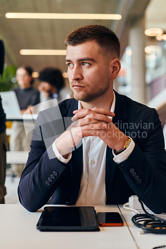 Image of In a modern office setting, a determined director sits confidently at his desk with crossed arms, exemplifying professionalism, leadership, and unwavering resolve in the contemporary corporate world