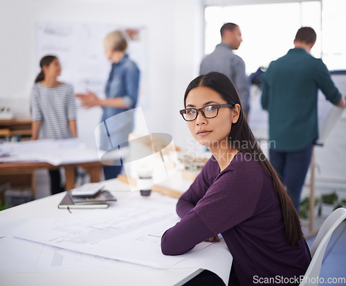 Image of One last check before submitting her plans. Portrait of a beautiful young architect studying blueprints.