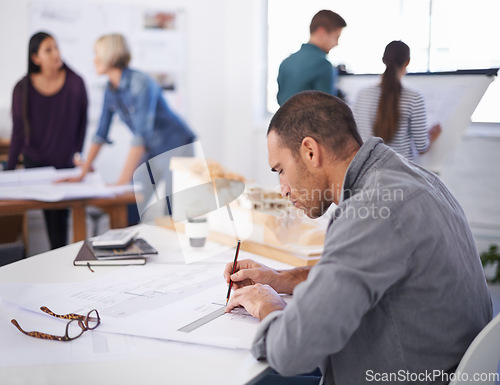 Image of Working hard to reach that deadline. a handsome architect working at his desk.