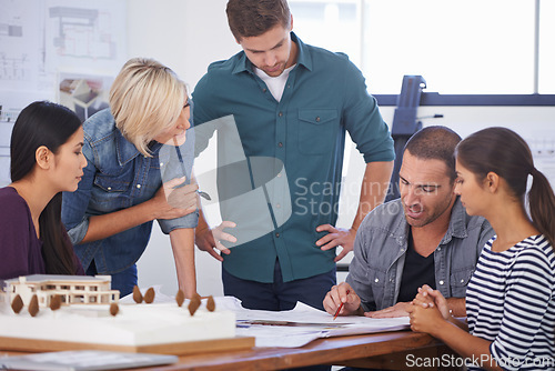 Image of Absorbing knowledge from an experienced architect. a group of architects discussing plans.