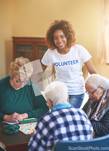 Image of She enjoys giving a helping hand. a volunteer working with seniors at a retirement home.