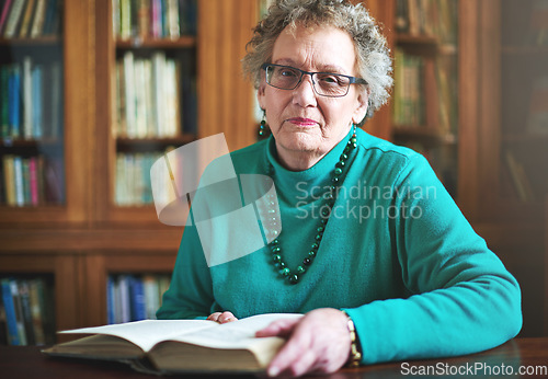 Image of Reading keeps my mind sharp. Portrait of a senior woman sitting at a table reading.