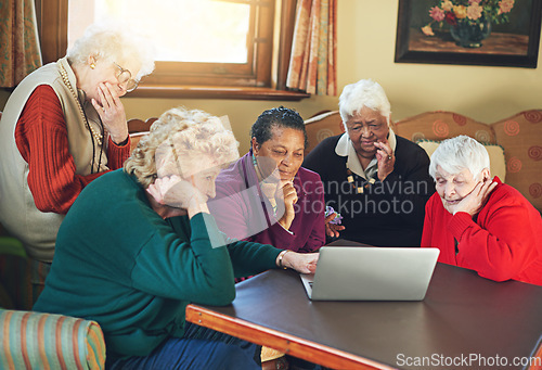 Image of Tech savvy senior citizens. a group of senior women using a laptop at a senior centre.