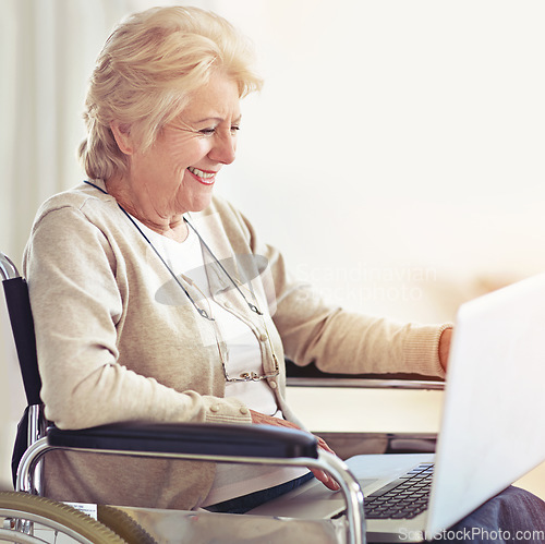 Image of Staying in touch with her family has never been easier. a senior woman using a laptop while sitting in a wheelchair.