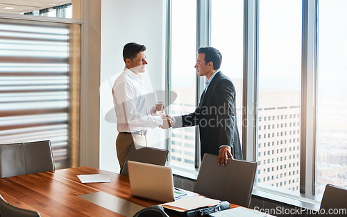 Image of The places well go...two businessmen shaking hands in a corporate office.