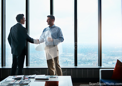 Image of It was a pleasure doing business with you. two businessmen shaking hands in a corporate office.