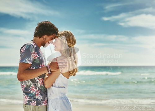 Image of Some moments last a lifetime. an affectionate young couple embracing on the beach.