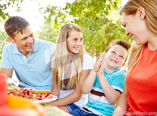 Image of Im so hungry. A happy young family relaxing in the park and enjoying a healthy picnic.