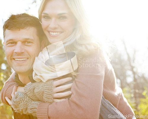 Image of Fun in the Fall. A happy man piggybacking his girlfriend while spending time in the woods.
