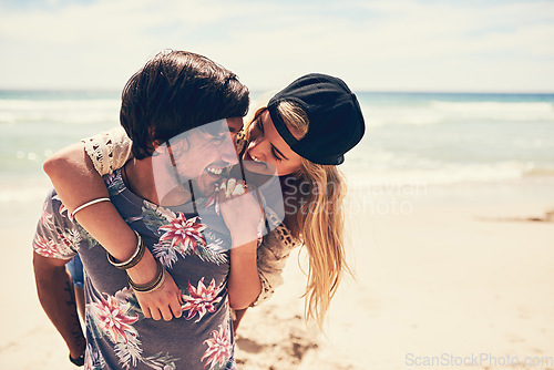 Image of Bonding on the beach. an attractive young woman getting a piggyback from her boyfriend on the beach.