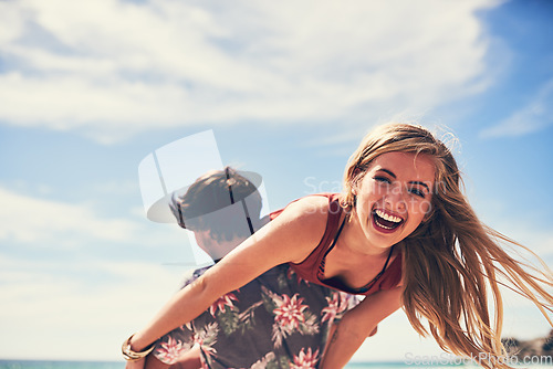 Image of Fun times on the beach. Portrait of an attractive young woman being carried by her boyfriend on the beach.