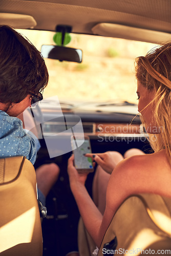 Image of Point me in the right direction, babe. Rearview shot of an affectionate young couple following their gps during a roadtrip.