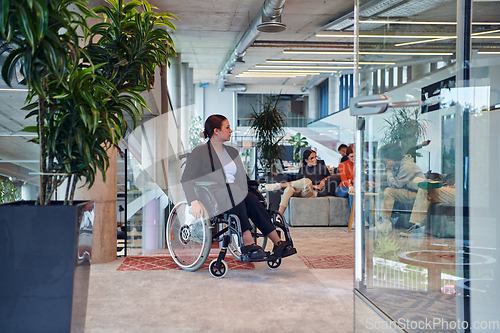 Image of In a modern office, a young businesswoman in a wheelchair is surrounded by her supportive colleagues, embodying the spirit of inclusivity and diversity in the workplace