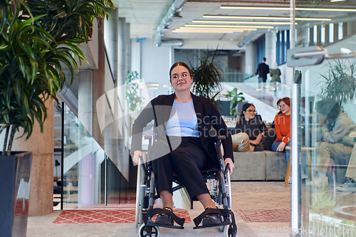 Image of In a modern office, a young businesswoman in a wheelchair is surrounded by her supportive colleagues, embodying the spirit of inclusivity and diversity in the workplace