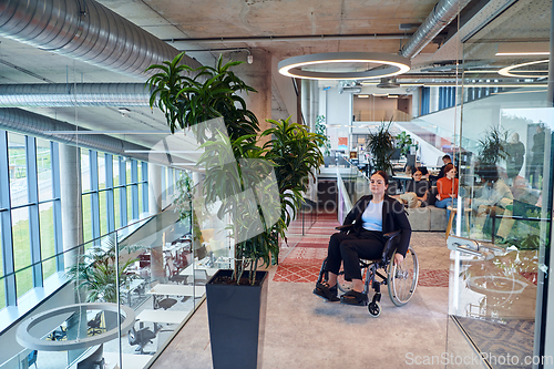 Image of In a modern office, a young businesswoman in a wheelchair is surrounded by her supportive colleagues, embodying the spirit of inclusivity and diversity in the workplace