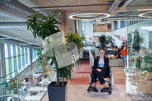 Image of In a modern office, a young businesswoman in a wheelchair is surrounded by her supportive colleagues, embodying the spirit of inclusivity and diversity in the workplace