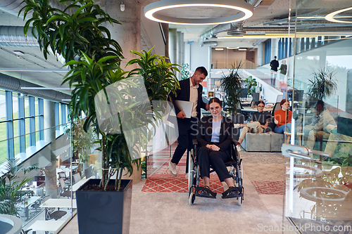 Image of In a modern office, a young businesswoman in a wheelchair is surrounded by her supportive colleagues, embodying the spirit of inclusivity and diversity in the workplace