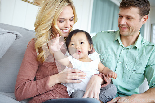 Image of Adoption Making dreams come true. A happy couple spending time with their beautiful adopted daughter while at home.