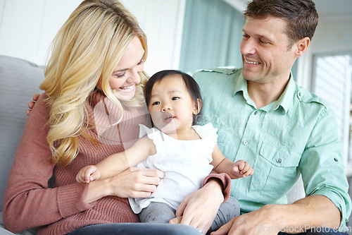 Image of Youre too cute, arent you. A happy couple spending time with their beautiful adopted daughter while at home.