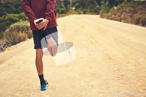 Image of Getting ready to take on the trail. Rearview shot of a young man warming up before a trail run.