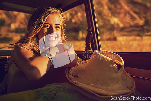 Image of On the road again. Portrait of a happy young woman sitting inside a car during a roadtrip.