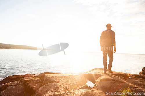 Image of Hiking is the perfect activity for you. a man wearing his backpack while out for a hike on a coastal trail.