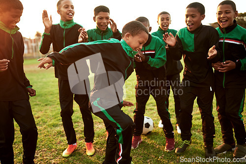 Image of Soccer is such a fun activity to be involved in. a boys soccer team cheering their teammate on a sports field.