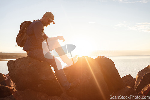 Image of Im wearing my favourite shoes for this hike. a man wearing his backpack while out for a hike on a coastal trail.