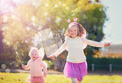 Image of Make way for the fairies fluttering by. Portrait of two little sisters dressed up as fairies and having fun outside.