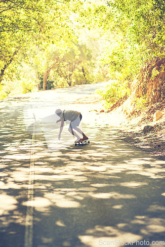 Image of Skating smoothly down the streets. Rearview shot of a young man longboarding in the street.