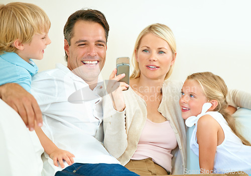 Image of Do you remember this. a woman showing her husband her phone while their two children sit next to them.