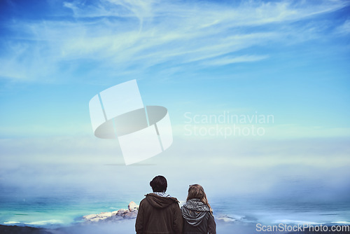 Image of Enjoying the view. Rearview shot of an affectionate young couple enjoying a hike in the mountains.