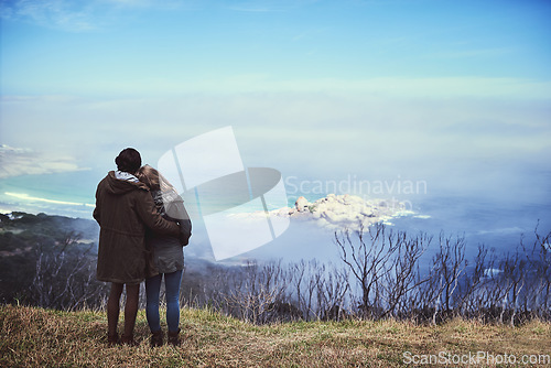 Image of Taking in the view. Rearview shot of an affectionate young couple enjoying a hike in the mountains.