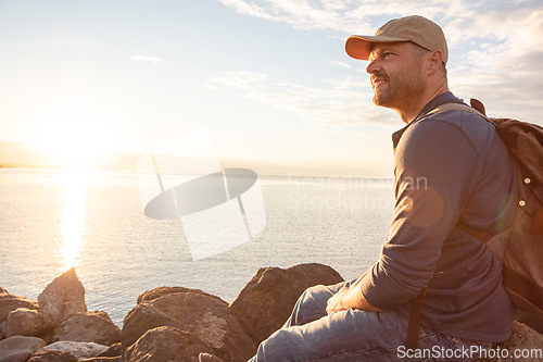 Image of Spend more time in natural settings. a man wearing his backpack while out for a hike on a coastal trail.