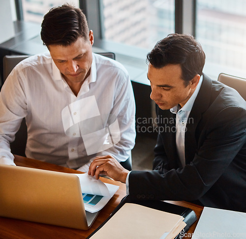 Image of Lets discuss these figures. two businessmen having a discussion while sitting by a laptop.