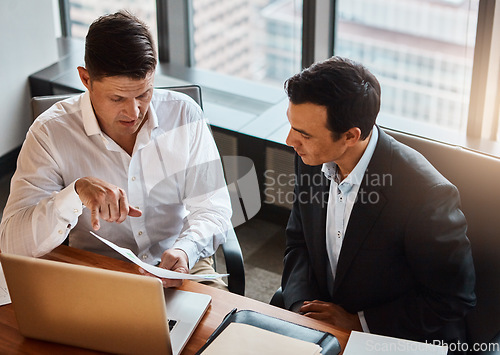 Image of We have all the resources to find a solution. two businessmen having a discussion while sitting by a laptop.