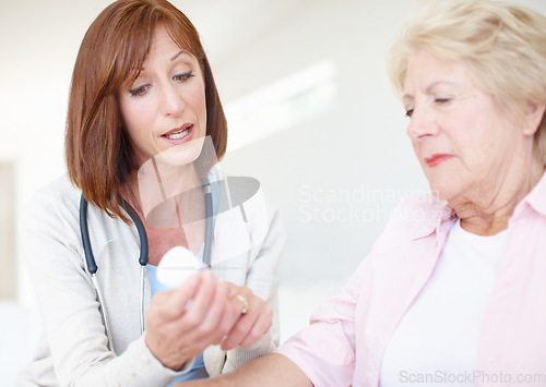 Image of Explaining the dosage and effects - Senior Care. Mature nurse explains the dosage and side effects of the medication to an elderly female patient.