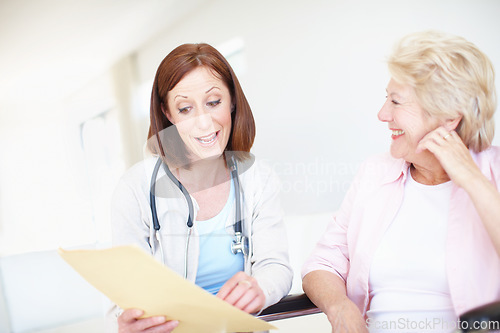 Image of These tests have come better that we could have hoped. Mature nurse gives the good news to her elderly wheelchair-bound patient.