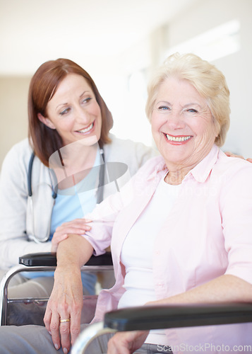 Image of Elderly patient put at ease by her caring doctor. Happy elderly female patient receives some welcome company from her doctor.