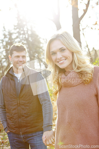 Image of Enjoying a walk in the Fall woods. An affectionate and romantic young couple spending time together in the woods.