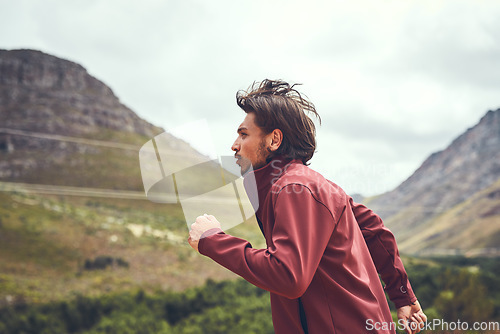 Image of It only gets better once you work up a sweat. a young man out for a trail run.