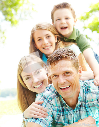 Image of Sharing matching smiles. A happy young family relaxing together on a sunny day.