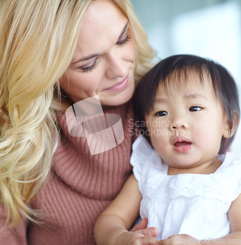 Image of Shes my blessing. Woman holding an adopted cute baby while sitting inside her home. Mother bonding with her young child. Parent showing love to her kid inside a house. Female caring for her daughter.