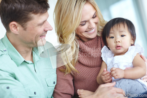 Image of Our little treasure. A happy couple spending time with their beautiful adopted daughter while at home.