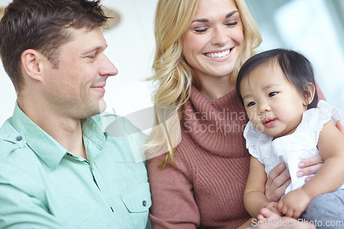 Image of Shes their angel. A happy couple spending time with their beautiful adopted daughter while at home.