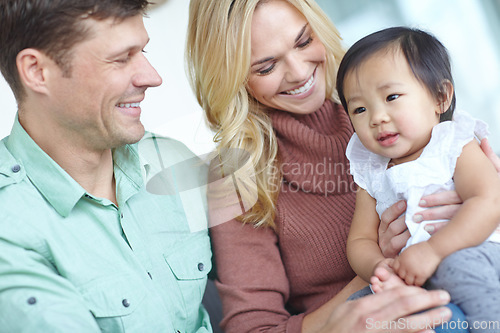 Image of She completes their life. A happy couple spending time with their beautiful adopted daughter while at home.