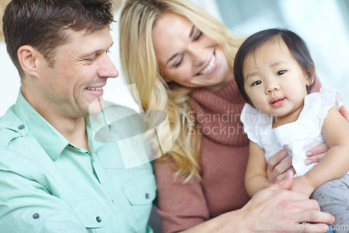 Image of Parenthood is so fulfilling. A happy couple spending time with their beautiful adopted daughter while at home.