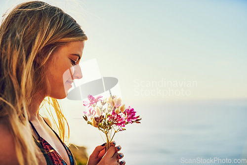 Image of Dont lose your connection to nature. a happy young woman holding a bunch of flowers while standing outside.