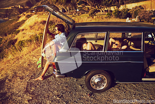Image of Go see whats out there. a young couple relaxing by their car during a roadtrip.